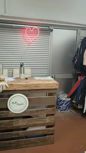 The 4UP Market Community Shop counter, with a neon heart on the wall